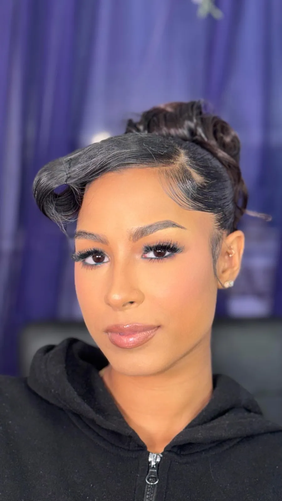 Glam makeup with a sleek updo on a Tyca Beaute client